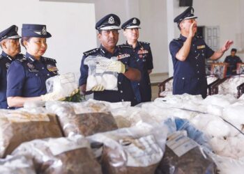 HUSSEIN Omar Khan (tengah) menunjukkan bungkusan dadah yang dirampas polis dalam pelbagai serbuan dan tangkapan di seluruh Selangor dalam sidang akhbar di Ibu pejabat Polis Kontinjen (IPK) Selangor di Shah Alam, semalam. - UTUSAN / AFIQ RAZALI