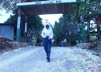 LENI berjalan kaki ke sekolah dari rumahnya di Dusun Langgaha Baru di di Sulawesi Tenggara.-AGENSI