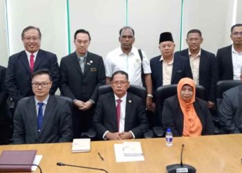 MOHD Amin (duduk tengah) menunjukkan siaran akhbar mengenai kesediaan MBPG pertimbang kadar cukai harta di Menara Aqabah, Pasir Gudang