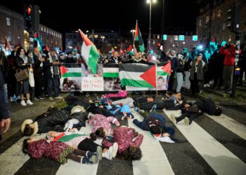 SEJUMLAH kanak-kanak berbaring atas jalan dalam perhimpunan pro-Palestin di Aarhus, Denmark. - AFP