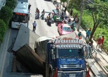 LUBANG mendapan besar di Jalan Sukhumvit menenggelamkan hampir seluruh lori muatan berat itu. - AGENSI