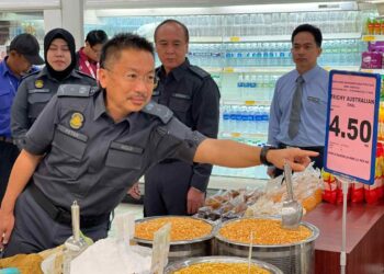 PETER J. Berinus Agang, menunjukkan harga kawalan bagi Kacang Dal (Australia) semasa tinjauan pelaksanaan Skim Harga Maksimum Musim Perayaan Deepavali 2033, di Mydin Samariang Kuching hari ini.