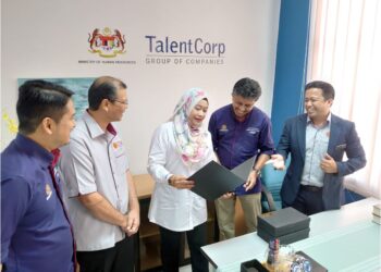 TAZRINA AHMAD (tengah) mendengar taklimat tentang pembukaan pejabat satelit pertama TalentCorp Zon Selatan di UTM Skudai, Johor Bahru.