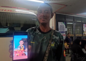 MOHD. Ali Abdul Rahman menunjukkan gambar anaknya, Muhammad Aidil Adha, 5, yang ditemukan lemas selepas terjatuh ke dalam kolam udang berdekatan rumahnya di Kampung Sungai Emas Hujung, Kota Kuala Muda di Sungai Petani. -UTUSAN/NUR SYAZWANA MANSOR