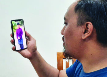 MOHAMAD Naquib Jasmi menunjukkan gambar Mohd Hafiz yang disimpan dalam telefon bimbitnya ketika ditemui di rumahnya di Kulim, Kedah semalam. – UTUSAN/AZAHAR HASHIM