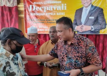 REEZAL MERICAN Naina Merican (kanan) menyantuni seorang penerima bantuan sempena Majlis Sumbangan Deepavali peringkat Kepala Batas, Pulau Pinang hari ini.