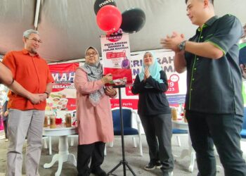 FUZIAH Salleh (dua dari kiri) menurunkan tandatangan perasmian Pesta Aiskrim Rahmah dan Jualan Rahmah di Kangar Jaya, Kangar, Perlis hari ini.-UTUSAN/SYED AZLAN SAYID HIZAR