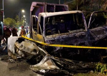 KEADAAN kereta yang terbakar setelah terlibat kemalangan dengan lori sampah di kawasan perindustrian Bercham, Ipoh semalam. - UTUSAN/IHSAN JBPM