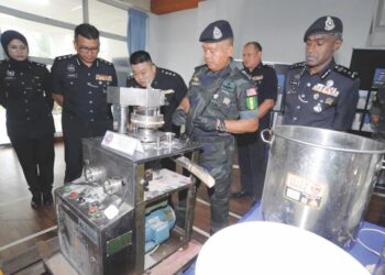 KAMARUL Zaman Mamat melihat mesin memproses dadah jenis ekstasi yang dirampas dalam serbuan di Pasir Gudang di IPD Bandar Seri Alam, Johor Bahru.