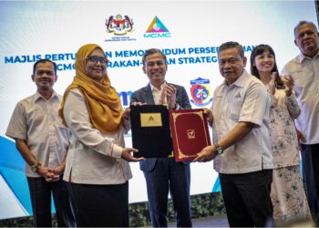 FAHMI Fadzil menyaksikan pertukaran memorandum persefahaman antara Ketua Pegawai Hal Ehwal Koporat MCMC, Datuk Zulkarnain Mohd Yasin dan Pengarah Komunikasi Strategik Felda, Mastura Abdul Manap di  Pusat Konvensyen Antarabangsa Putrajaya (PICC), Putrajaya di sini, hari ini. - UTUSAN/FAIZ ALIF ZUBIR