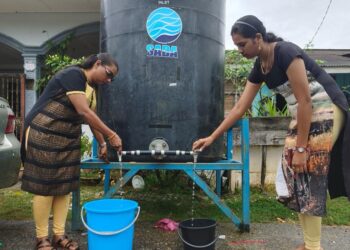 PENDUDUK menadah air daripada tong yang disediakan SADA di Taman Sungai Raya, Langkawi. -UTUSAN/NUR AMALINA AZMAN