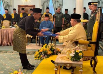 TUANKU Syed Sirajuddin Putra Jamalullail berkenan menyerahkan watikah pelantikan sebagai Exco kepada Asrul Aimran Abd Jalil dalam majlis angkat sumpah di Istana Arau hari ini. -UTUSAN/ASYRAF MUHAMMAD