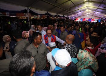 ANWAR Ibrahim (tengah) disambut meriah orang ramai yang hadir pada Ceramah Mega Perpaduan Madani PRK Parlimen Kemaman, di Geliga, Kemaman, malam ini. - UTUSAN/PUQTRA HAIRRY ROSLI