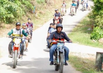 ABDUL Rahman Mohamad (depan, kanan) mengetuai peserta motosikal lasak untuk merasmikan Litar Lasak Tok Man di Kampung Kuala Lanar, Lipis, hari ini. - UTUSAN/HARIS FADILAH AHMAD
