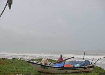 Nelayan, Mohd Ngah Abu Bakar, 75, mengemas peralatan botnya untuk disimpan selepas tidak dapat turun ke laut untuk mencari rezeki berikutan keadaan laut bergelora susulan fenomena Monsun Timur Laut i Kampung Jambu Bongkok, Marang semalam. -UTUSAN/PUQTRA HAIRRY