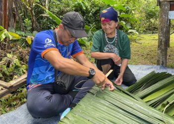 TIMBALAN Pengarah PLUMS, Dr. Muhamad Suhaimi Taat mempelajari seni menganyam daun atap bersama salah seorang penduduk kampung.