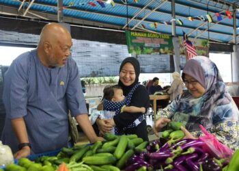 RAJA Mohamed Affandi Raja Mohamed Noor beramah mesra bersama peniaga dan pengunjung di Pasar Borong Dusun Nyior, Chukai, Kemaman, hari ini. - UTUSAN/NIK NUR  NUR IZZATUL HAZWANI NIK ADNAN