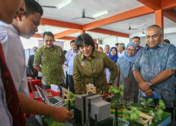 TUNKU Puteri Intan Safinaz (tengah) bersama Mohd. Izani Ghani (dua kiri) dan Noorazman Abd. Aziz (kanan) mendengar penerangan pelajar ketika melawat pameran pada majlis penutup STEM and English Programme anjuran YUEM dan YSB di Pendang Lake Resort. - UTUSAN/ SHAHIR NOORDIN