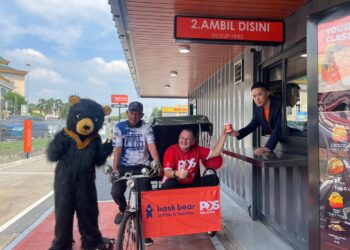 CHARLES Brewer menerima layanan Bryan Loo sebagai simbolik pelancaran kios pandu lalu BBC di Pejabat Pos Besar Melaka, Bukit Baru, Melaka. - UTUSAN/AMRAN MULUP