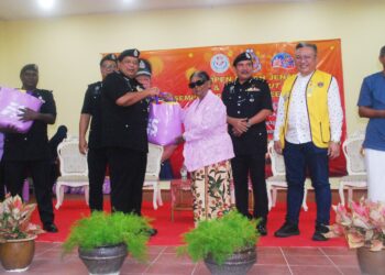 ZAINOL Samah menyampaikan bantuan makanan kepada seorang penerima selepas merasmikan Kempen Cegah Jenayah dan Jelajah Mesra Sempena Deepavali di Kampung Chetti, Melaka. - UTUSAN/AMRAN MULUP
