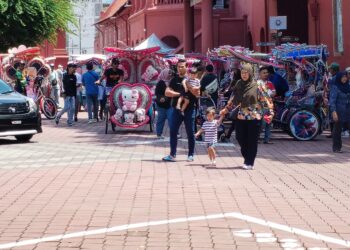 SUASANA meriah melihat kebanjiran pelancong di Bangunan Stadthuys, Banda Hilir Melaka. - UTUSAN/AMRAN MULUP