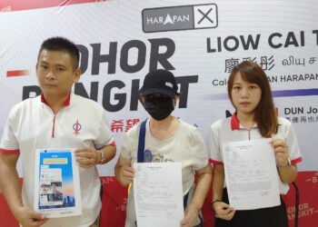 TIOW (tengah) dan Wern Yiing (kanan) menunjukkan laporan polis yang dibuatnya kerana menerima ugutan daripada sembilan kumpulan ah long di Pejabat Khidmat ADUN Johor Jaya, Johor Bahru.