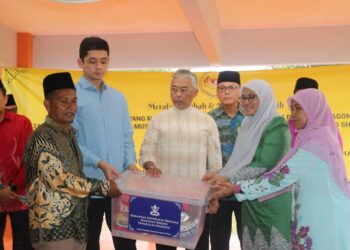 AL-SULTAN ABDULLLAH Ri’ayatuddin Al-Mustafa Billah Shah (tengah) menyampaikan bantuan makanan kering musim banjir kepada Abdul Jabar Dollah (kiri) di pinggir Sungai Tembeling, Ulu Tembeling di Jerantut, Pahang. - UTUSAN/SALEHUDIN MAT RASAD