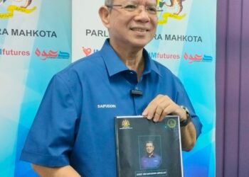 SAIFUDDIN Abdullah menunjukkan buku laporan setahun bagi Parlimen Indera Mahkota bagi tahun ini, selepas sidang akhbar di Pusat Khidmat Parlimen Indera Mahkota di Kuantan, Pahang. - UTUSAN/DIANA SURYA ABD WAHAB