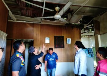 SAFRI Abdul Khalid memperkatakan sesuatu kepada Kerk Chee Yee mengenai kerosakan rumahnya di Kampung Pulau Samak, Batu Berendam, Melaka. - UTUSAN/AMRAN MULUP