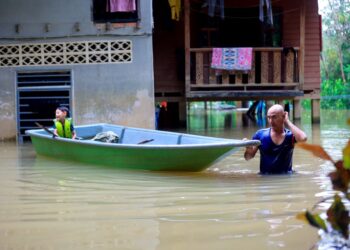 SEORANG penduduk kampung membawa anaknya menaiki sampan untuk keluar dari rumahnya yang ditenggelami air di Kampung Tersang, Rantau Panjang, semalam.-UTUSAN/KAMARUL BISMI KAMARUZAMAN