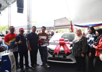 RUBIAH Wang menyampaikan hadiah cabutan bertuah kepada pengunjung bertuah, Mohammad Amirul Ashraf Napi yang memenangi hadiah kereta Perodua Myvi pada majlis penutup KUD@Putrajaya.