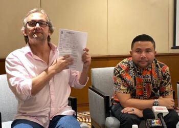 WARGA England, Lee Roger Meikhlejohn (kiri) menunjukkan laporan polis berkaitan pelaburan palsu didalangi lelaki bergelar Datuk di Hotel Eastin, Petaling Jaya hari ini.
