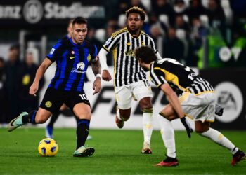 Lautaro Martinez (kiri) cuba melepasi dua pemain Juventus dalam saingan Serie A di Turin. - AFP