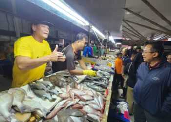 AHMAD Samsuri (kanan) beramah mesra dengan peniaga ikan ketika kempen PRK Kemaman  di Pasar Binjai, Kemaman, hari ini. - UTUSAN/ NIK NUR IZZATUL HAZWANI NIK ADNAN