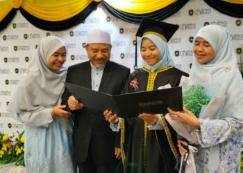 MOHD. Nassuruddin Daud meraikan kejayaan anak bongsunya, Amanina (dua dari kanan) pada sesi terakhir Majlis Idul Ilmi Konvokesyen UniSZA Kali Ke-15 di Kuala Nerus, hari ini. - UTUSAN/KAMALIZA KAMARUDDIN