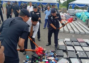 MOHD. Zaid Hassan (kanan) melupuskan barang kes seperti mesin komputer, telefon bimbit dan kad ATM di Balai Polis Bandar Baru Bangi, hari ini.