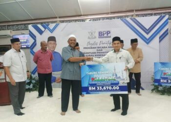 KADI Maran, Amirul Farhan Wahi (kanan) menyampaikan kutipan derma untuk Palestin berjumlah RM33,670 kepada Syed Ibrahim Syed Ahmad (dua dari kanan) di Felda Jengka 23 di Maran, Pahang. - FOTO/SALEHUDIN MAT RASAD