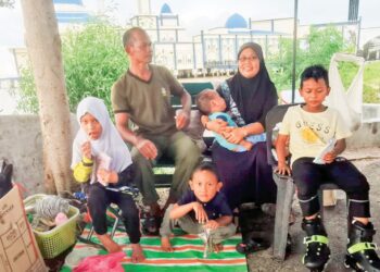 SUZILAWATI Samaon dan suami bersama empat beradik yang dijaga sementera ketika ditemui di Bagan Datuk, semalam. - UTUSAN/AIN SAFRE BIDIN
