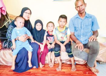 SUZILAWATI  Samaon (kiri) dan suami bersama empat beradik yang mereka jaga di Batu 25 Bagan Datuk. -UTUSAN/AIN SAFRE BIDIN