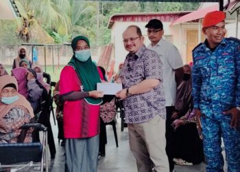 SHAMSUL Iskandar Mohd. Akin menyerahkan bantuan khas Perdana Menteri kepada mangsa banjir di SK Changkat Lobak di Bagan Serai. - UTUSAN/WAT KAMAL ABAS