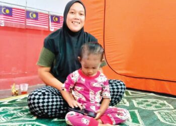FATIN Norhamimi Dzulkatly bersama anak sulungnya antara 157 mangsa banjir yang ditempatkan di PPS SK Alor Pongsu di Bagan Serai. - UTUSAN/WAT KAMAL ABAS