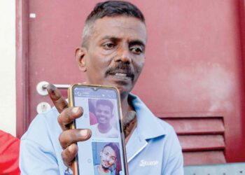M. Manimaran menunjukkan gambar anaknya, M. Krishna, 20, (kiri) dan lPavilesh,16, ketika ditemui di Jabatan Forensik Hospital Raja Permaisuri Bainun Ipoh hari ini. – UTUSAN/MUHAMAD NAZREEN SYAH MUSTHAFA