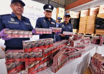 MOHAMMAD Hafiz Ishak (tengah) menunjukkan sebahagian rokok lori cukai yang dirampas pada sidang akhbar di Seremban hari ini.-UTUSAN/MOHD. SHAHJEHAN MAAMIN.
