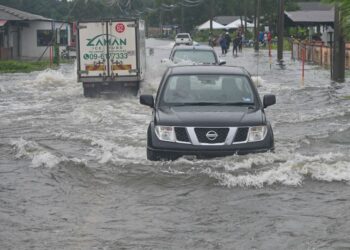 BEBERAPA kenderaan meredah banjir ketika tinjauan di Kampung Alur, Surau Panjang di Kuala 
Terengganu semalam. – UTUSAN/PUQTRA HAIRRY