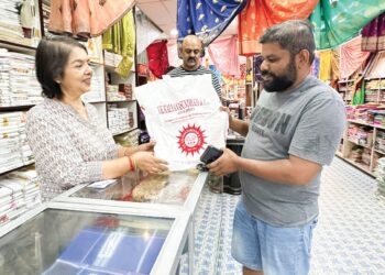 B. KALA (kiri) melayan pelanggan yang membeli baju baharu untuk Deepavali di kawasan perniagaan Little India di Ipoh. – UTUSAN/LIYANA RAMLI