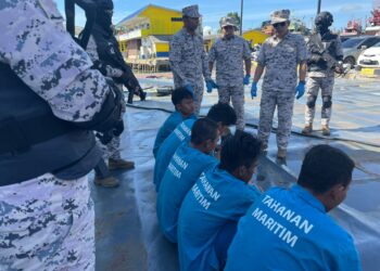 SYED NOR ADLI Syed Abd. Rahman (kanan) semasa melakukan pemeriksaan ke atas lima nelayan asing Vietnam yang ditahan di Tok Bali, Pasir Puteh, Kelantan, hari ini. UTUSAN/ TOREK SULONG.