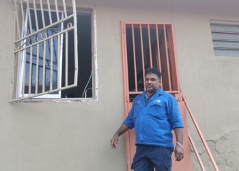 M. GUNASEGARAN menunjukkan pintu dapur rumahnya di Taman Bukit Seri Senawang, Seremban yang dipecah masuk dua lelaki bertopeng bersenjatakan parang dalam kejadian awal pagi tadi.
