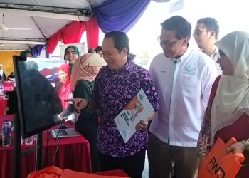AHMAD Maslan (kiri) melawat reruai pameran pada program Takaful Masuk Kampung di Kampung Puteri Menangis, Pontian. - UTUSAN/MUHAMMAD ZIKRI