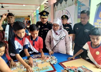 MOHD. Edir Sanip (tengah) bersama Hasrunizah Hassan (dua dari kanan) melihat murid-murid melakukan aktiviti berkaitan undang-undang jalan raya di SK Ayer Baloi, di Pontian.-UTUSAN / MUHAMMAD  ZIKRI
