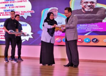 AZIRA Ismail (dua dari kanan) menyampaikan dua naskhah buku kepada Tuan Zainal Abidin Tuan Yusuf atas kesudian merasmikan Karnival Semarak Bahasa di Tunjong, Kota Bharu, Kelantan hari ini. UTUSAN/MUSTAQIM MOHAMED